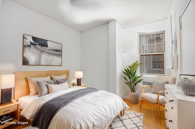 bedroom with ornamental molding and light wood-style floors