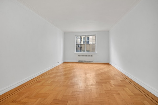 empty room with crown molding, baseboards, and radiator