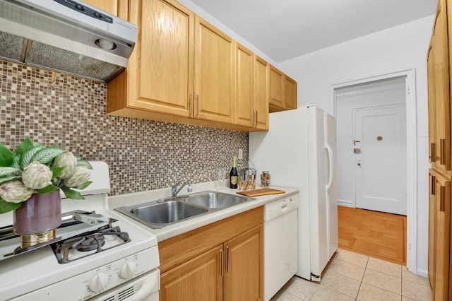 kitchen with white appliances, under cabinet range hood, a sink, light countertops, and tasteful backsplash