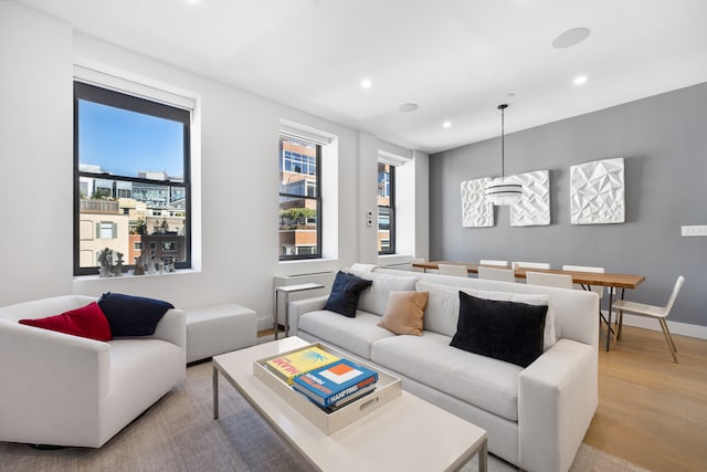 living room featuring light wood finished floors, plenty of natural light, recessed lighting, and baseboards