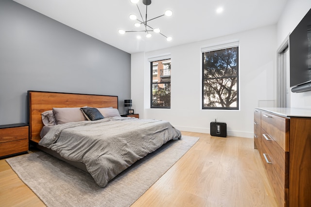 bedroom with a chandelier, light wood-type flooring, baseboards, and recessed lighting