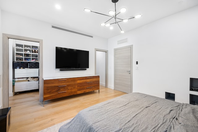 bedroom featuring a chandelier, light wood-type flooring, and visible vents