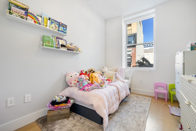 bedroom with wood finished floors and baseboards