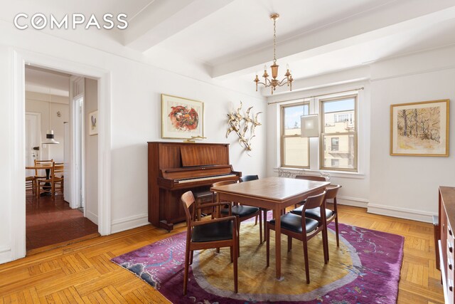 dining area featuring beam ceiling, a notable chandelier, and baseboards