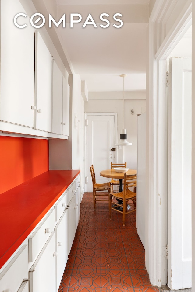 20 W 77th St Unit 15A, New York City, NY 10024 - kitchen with white cabinetry, freestanding refrigerator, and hanging light fixtures