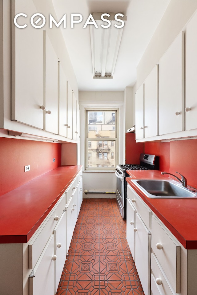 20 W 77th St Unit 15A, New York City, NY 10024 - kitchen featuring stainless steel range with gas cooktop, a sink, white cabinetry, and tasteful backsplash