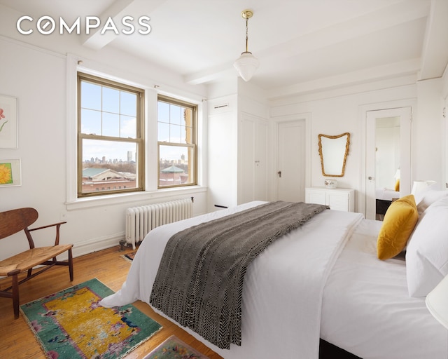 20 W 77th St Unit 15A, New York City, NY 10024 - bedroom featuring radiator, wood finished floors, beamed ceiling, and baseboards