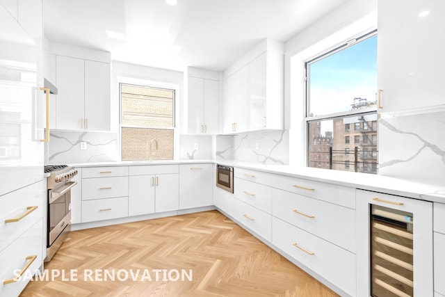 kitchen featuring beverage cooler, white cabinets, a sink, and high end stainless steel range