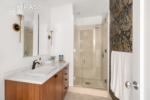 bathroom with tile patterned flooring, a shower stall, and vanity