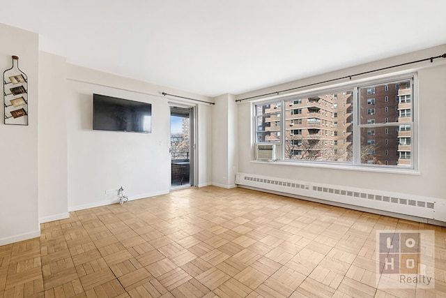 spare room with baseboards and a baseboard heating unit