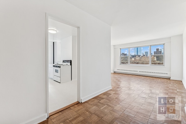 corridor featuring a baseboard heating unit, a city view, and baseboards