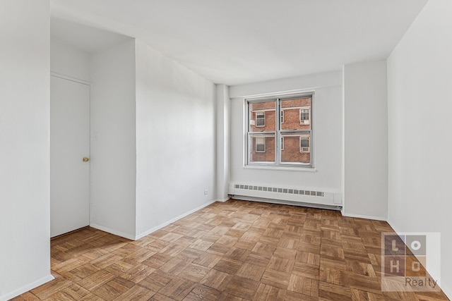 empty room with radiator heating unit, a baseboard radiator, and baseboards