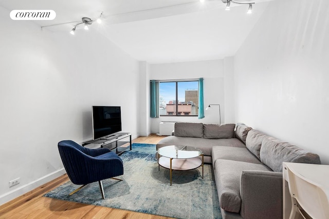 living room with visible vents, rail lighting, baseboards, and wood finished floors