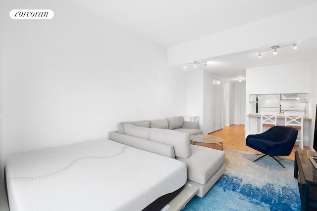 living room featuring track lighting, light wood-style floors, and visible vents