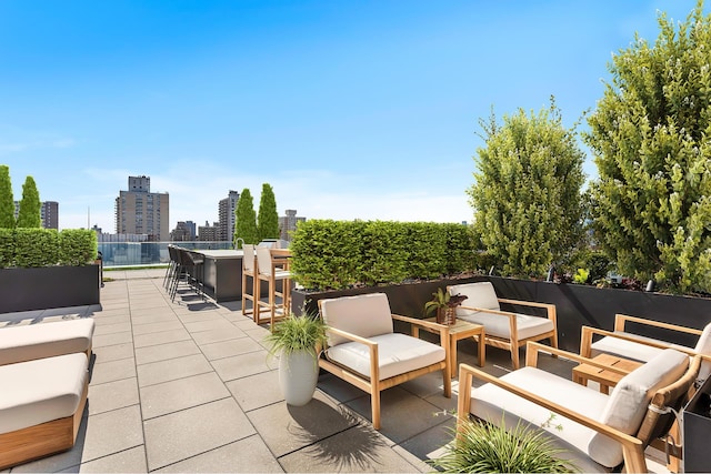 view of patio / terrace featuring a view of city, outdoor dry bar, and an outdoor hangout area