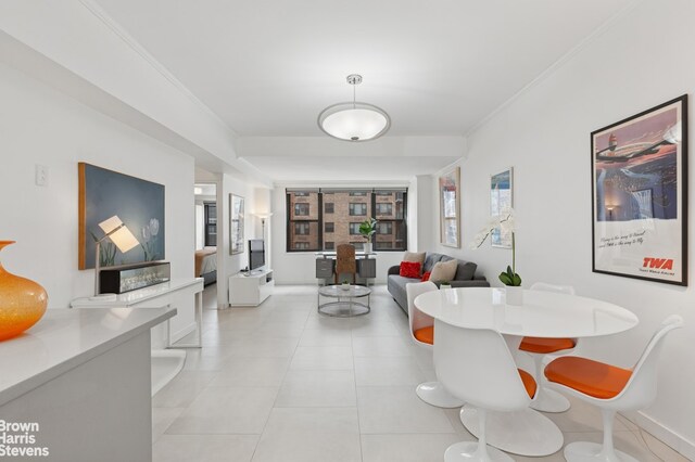 dining space featuring baseboards, ornamental molding, and light tile patterned flooring