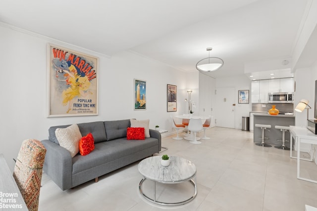 living area with light tile patterned floors, crown molding, and baseboards