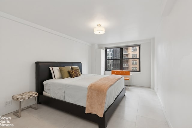 bedroom with light tile patterned flooring and baseboards