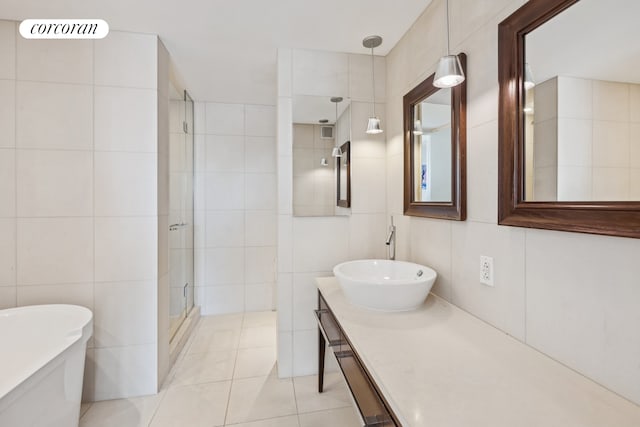 bathroom featuring tile walls, a shower stall, a soaking tub, tile patterned floors, and vanity