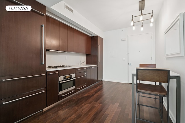 kitchen with stainless steel appliances, modern cabinets, dark wood-type flooring, and light countertops