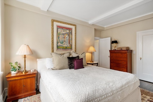 bedroom featuring beamed ceiling and wood finished floors