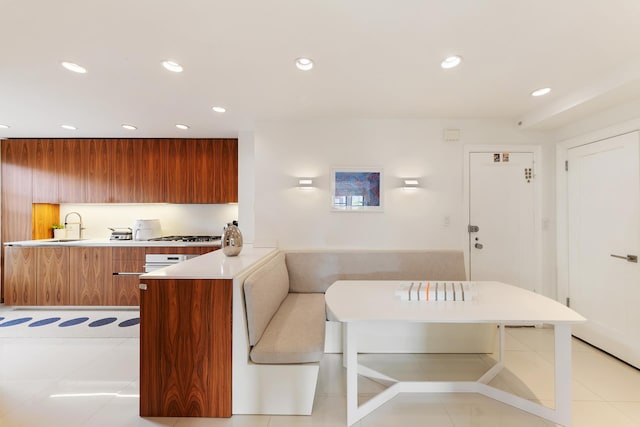 kitchen with light countertops, recessed lighting, modern cabinets, and brown cabinets