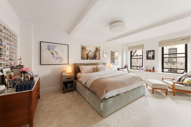 bedroom with light carpet, baseboards, and beam ceiling