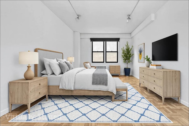 bedroom featuring baseboards and track lighting