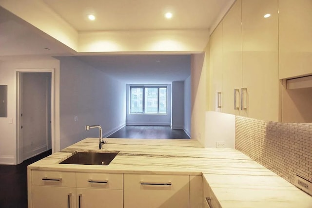 kitchen with dark wood-style floors, tasteful backsplash, recessed lighting, a sink, and baseboards