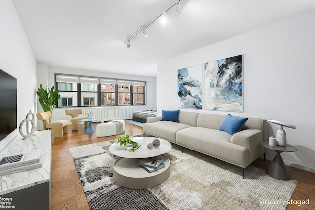 living area with track lighting and wood finished floors