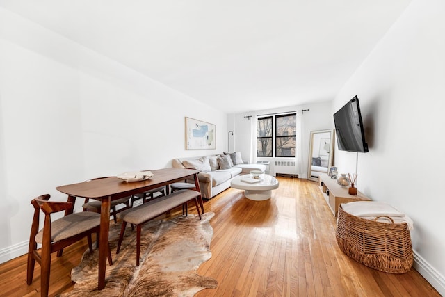 living area featuring baseboards and light wood-type flooring