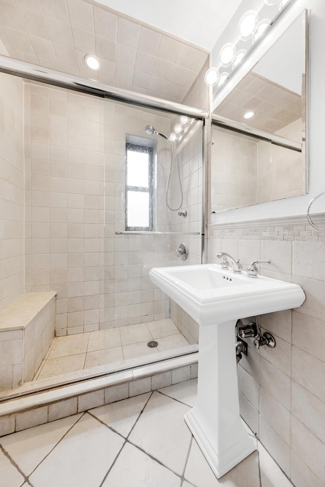 full bath featuring tile walls, tile patterned flooring, and a stall shower