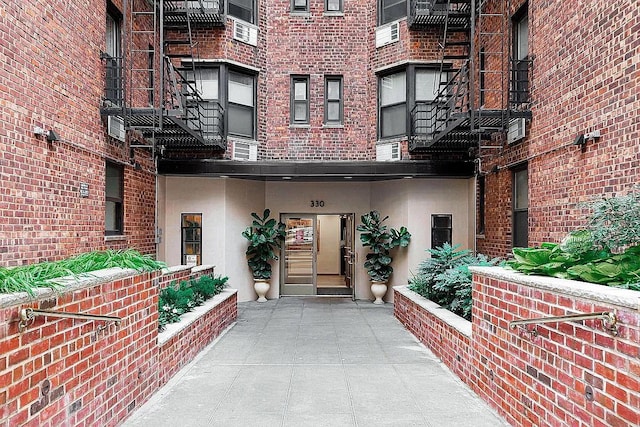 view of exterior entry with brick siding and stucco siding