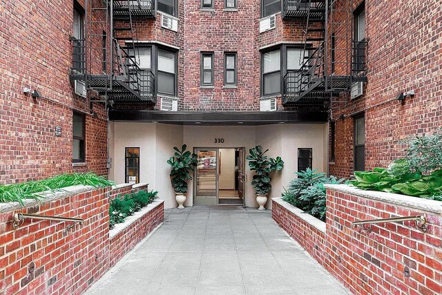 330 E 70th St Unit 4Ef, New York City, NY 10021 - view of exterior entry with stucco siding and brick siding
