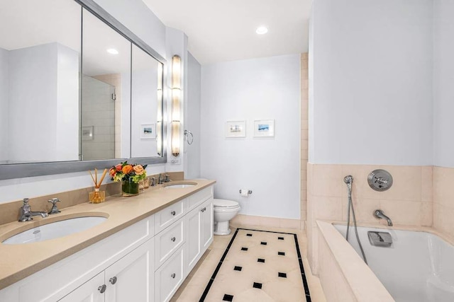 bathroom featuring a bath, toilet, double vanity, tile patterned flooring, and baseboards