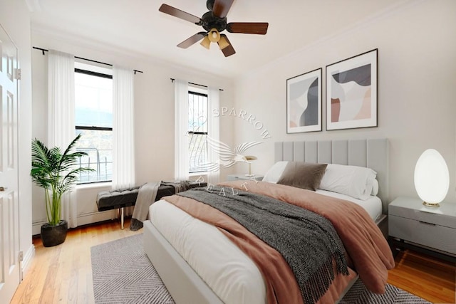 bedroom with ceiling fan, multiple windows, light wood-style flooring, and ornamental molding