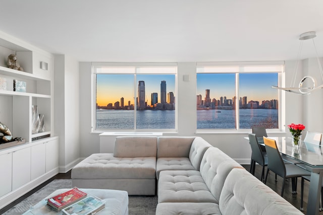 living room featuring a view of city, plenty of natural light, dark wood finished floors, and baseboards