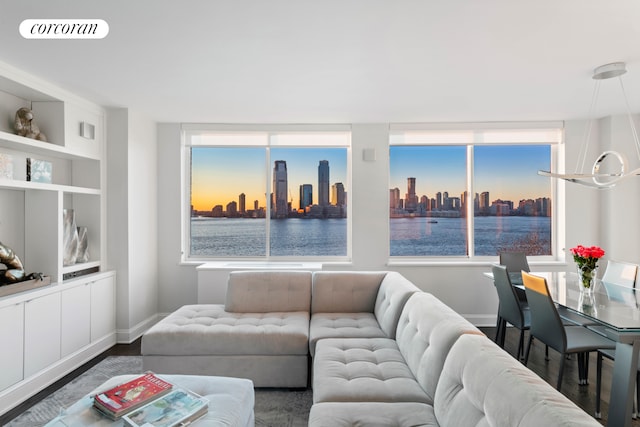 living room with dark wood finished floors, visible vents, a healthy amount of sunlight, and a view of city