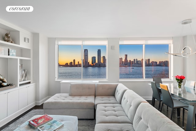 living room with visible vents, a view of city, baseboards, built in shelves, and dark wood finished floors