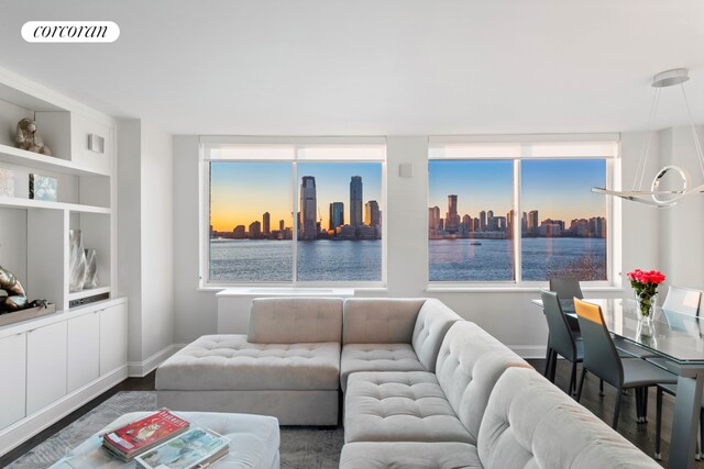 21 S End Ave Unit 722, New York City, NY 10280 - living room with visible vents, a view of city, baseboards, built in shelves, and dark wood finished floors