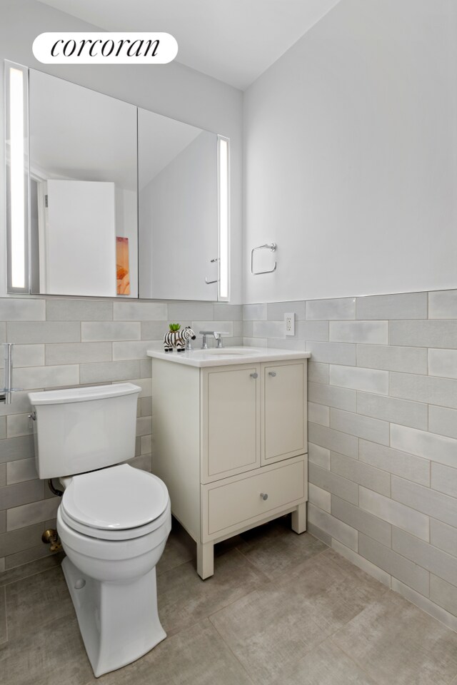 21 S End Ave Unit 722, New York City, NY 10280 - bathroom with toilet, tile walls, a wainscoted wall, and vanity