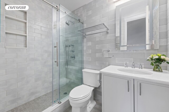 21 S End Ave Unit 722, New York City, NY 10280 - full bathroom with vanity, a stall shower, toilet, and tile walls