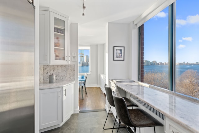 dining space featuring a view of city, built in desk, track lighting, and baseboards