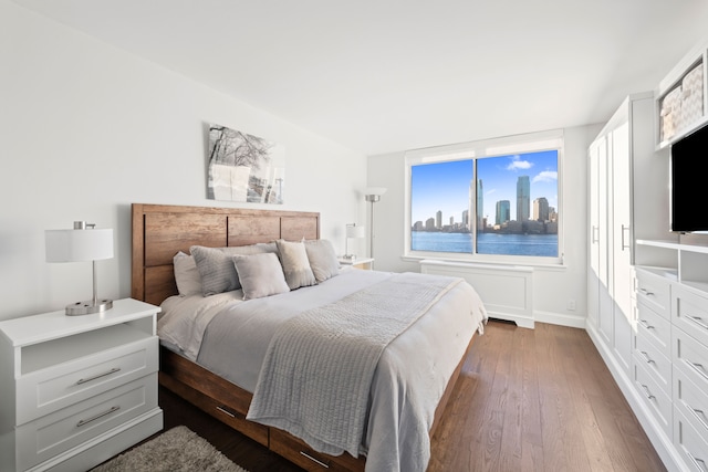 bedroom with baseboards and dark wood-style flooring