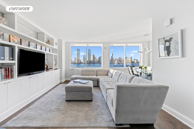 living room featuring baseboards, dark wood-style flooring, visible vents, and built in shelves
