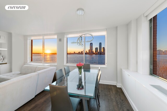 21 S End Ave Unit 722, New York City, NY 10280 - dining area with an inviting chandelier, a water view, dark wood-style floors, and visible vents