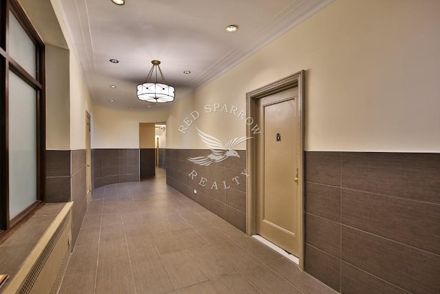 hall with tile walls, a wainscoted wall, ornamental molding, and recessed lighting