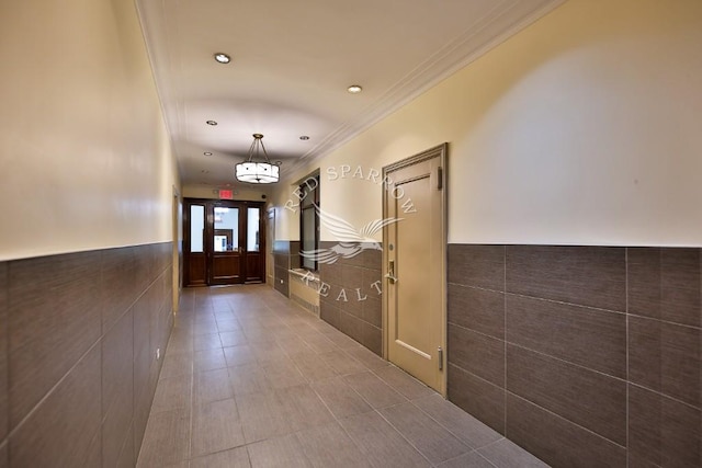hall with wainscoting, crown molding, tile walls, and recessed lighting