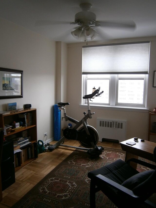 workout room featuring a healthy amount of sunlight and radiator heating unit