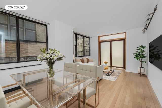 dining area featuring visible vents, light wood-style flooring, and baseboards